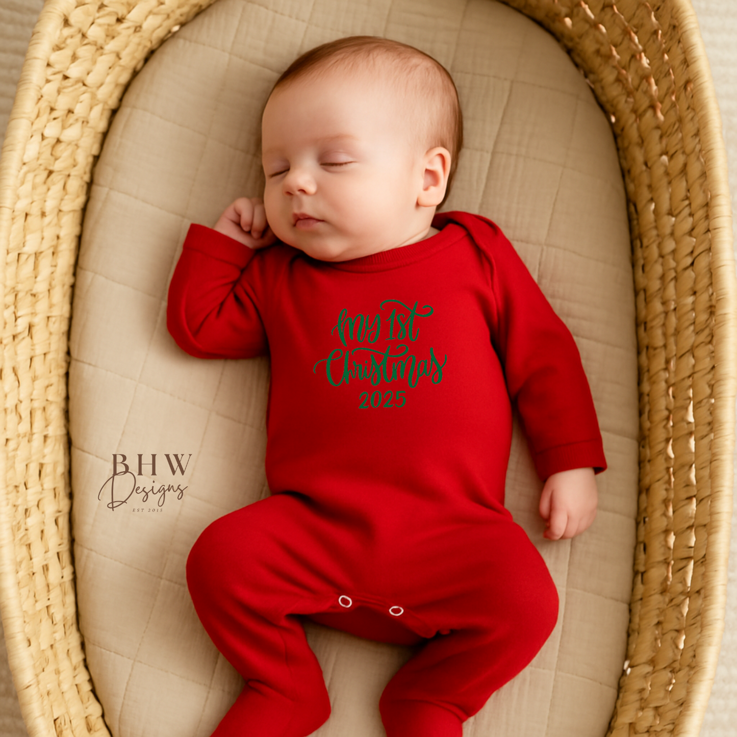 Baby in a red onesie sleeping in a woven basket with My 1st Christmas on the front in Green 