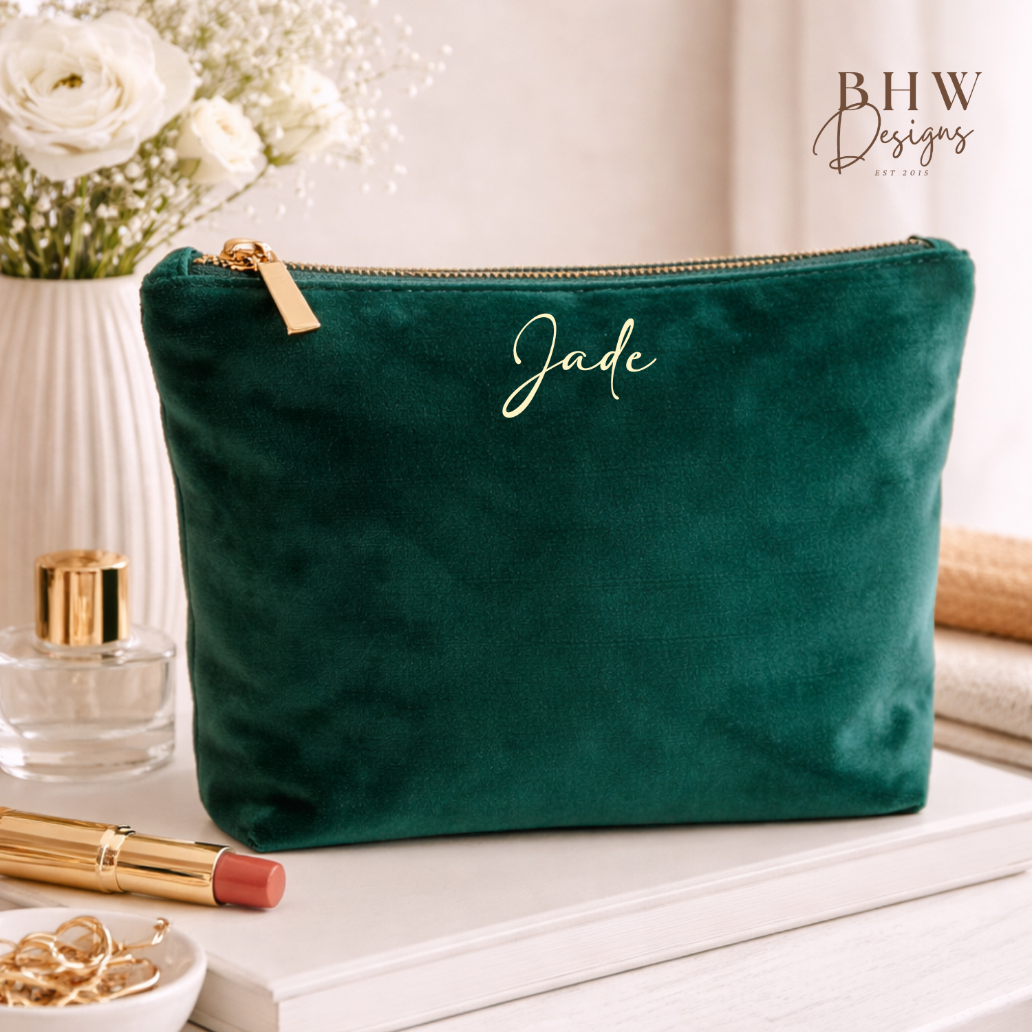 Green velvet pouch with 'Jade' branding on a table with beauty products.