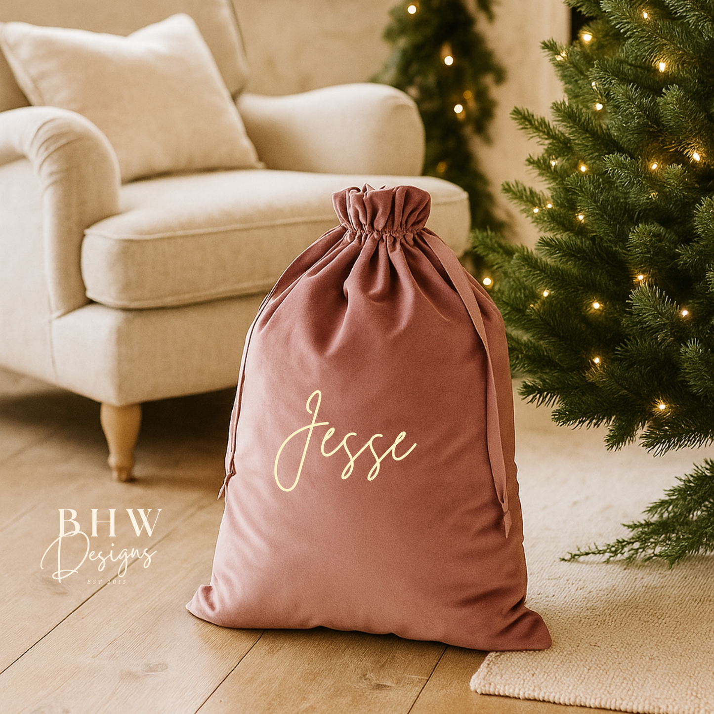 Pink drawstring bag with 'Jesse' written on it in a cozy living room with a Christmas tree.