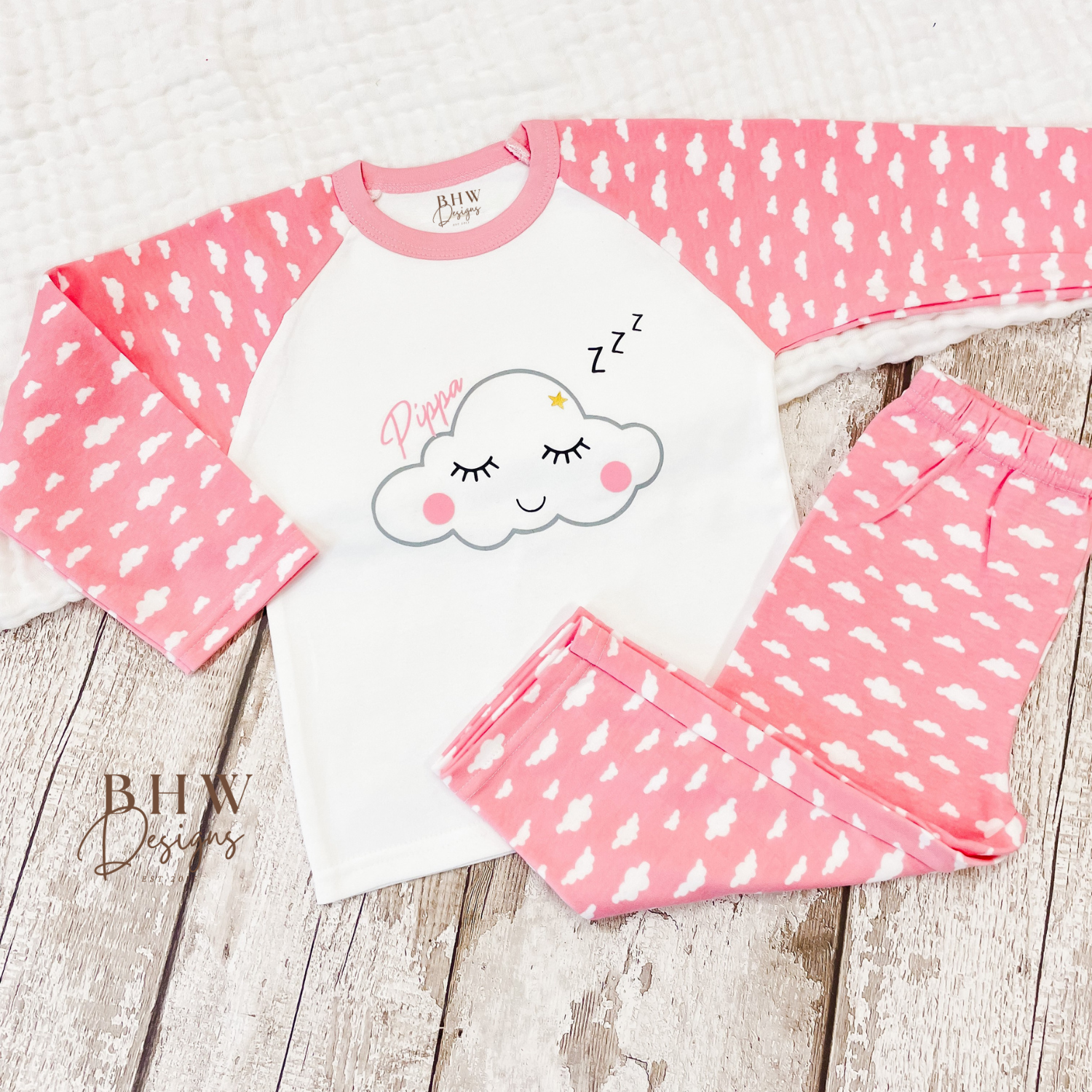 Children's pink pyjama set with cloud design personalised with name. 