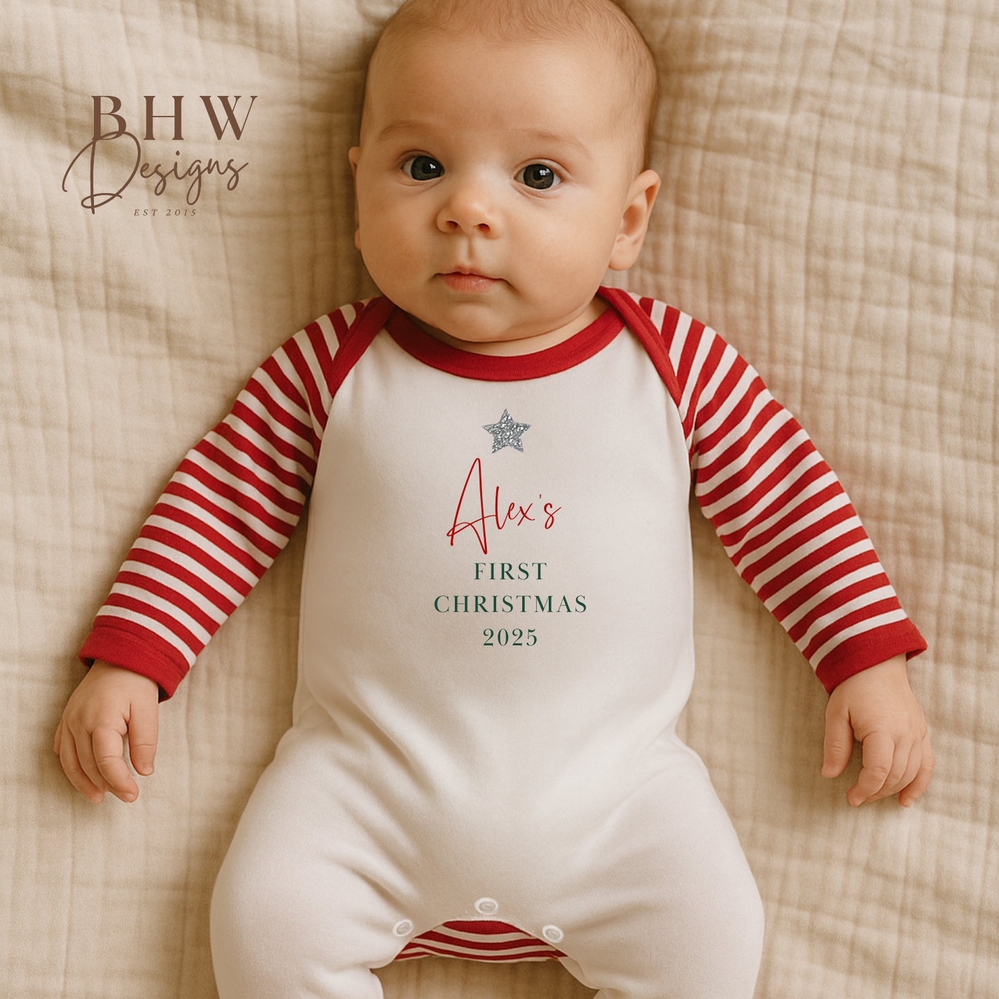 Baby wearing a red and white striped onesie with 'Alex's First Christmas 2025' 