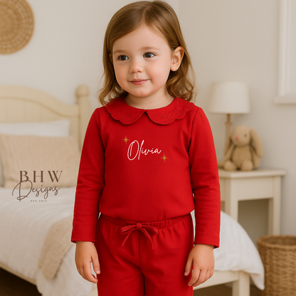 Child wearing red pyjamas with lace detail collar personalised n white with gold glitter stars 