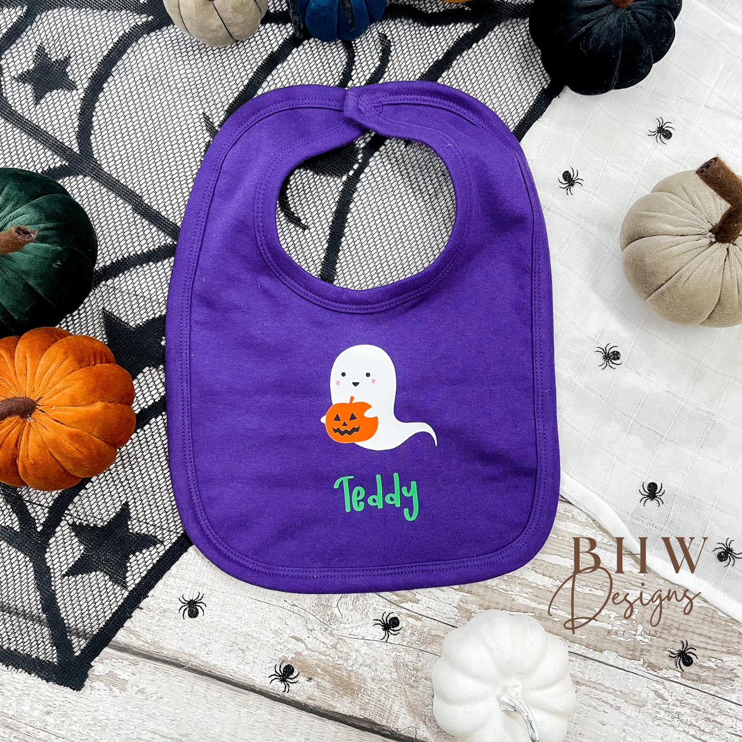 personalised Purple bib with ghost and pumpkin design on a Halloween-themed background