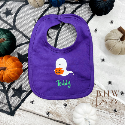 personalised Purple bib with ghost and pumpkin design on a Halloween-themed background