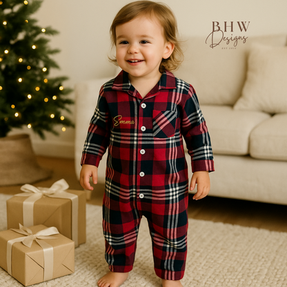 A child wearing a tartan patterned romper onesie for babies, personalised on the front with a name in script font 