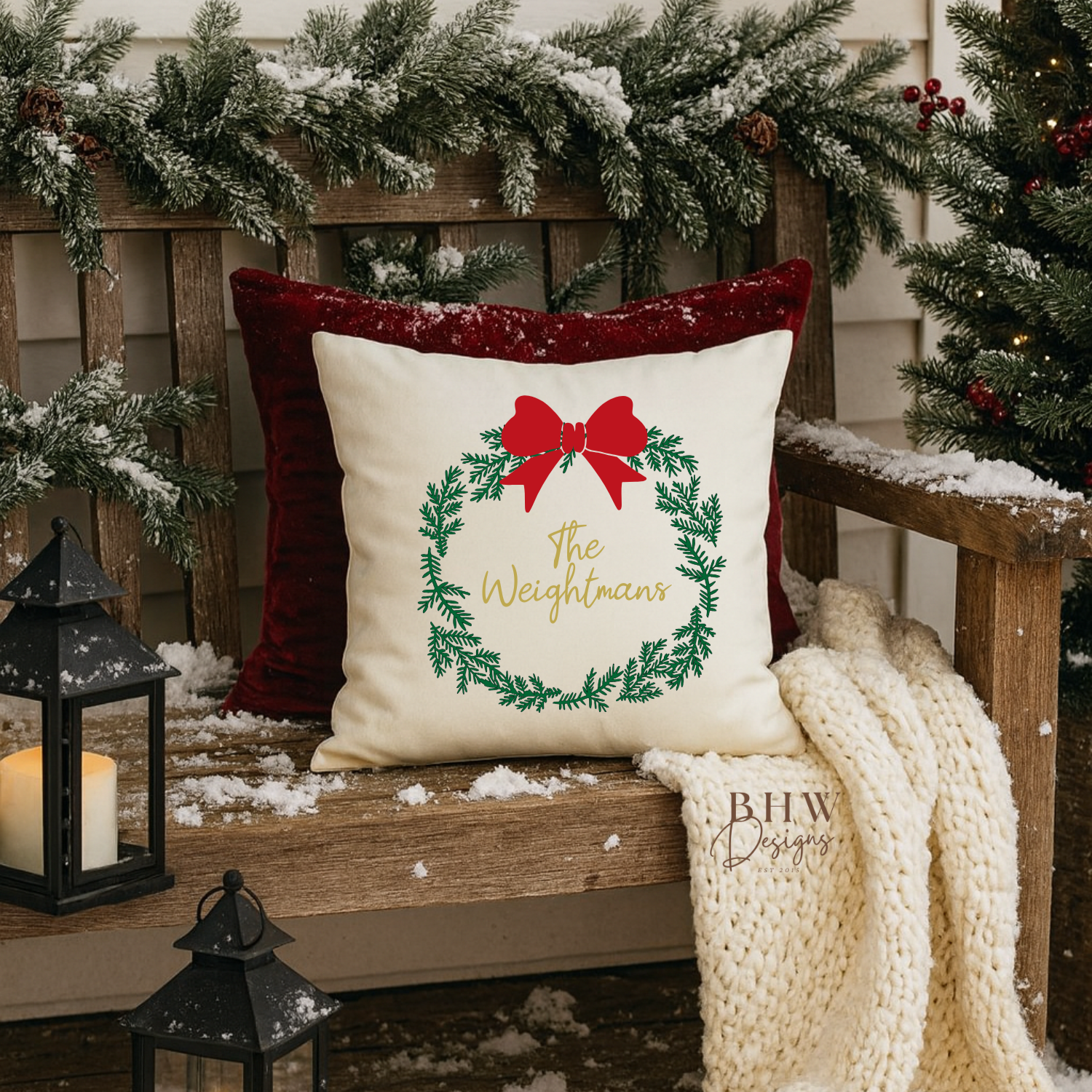 decorative personalised wreath and bow design cushion cover on a wooden bench with Christmas decorations.