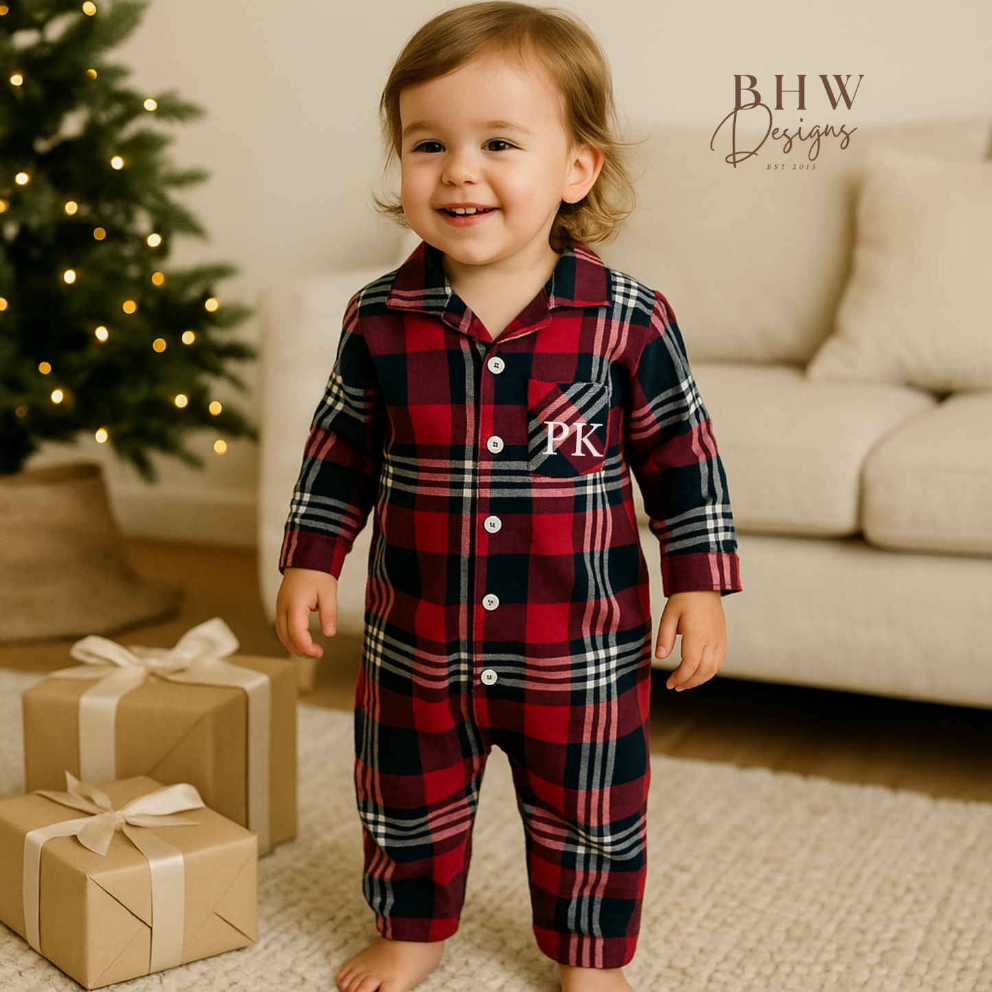 Child wearing a red and blue plaid onesie with 'PK' in white on the front