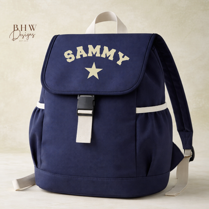 Navy blue backpack with 'SAMMY' and a star on a beige background