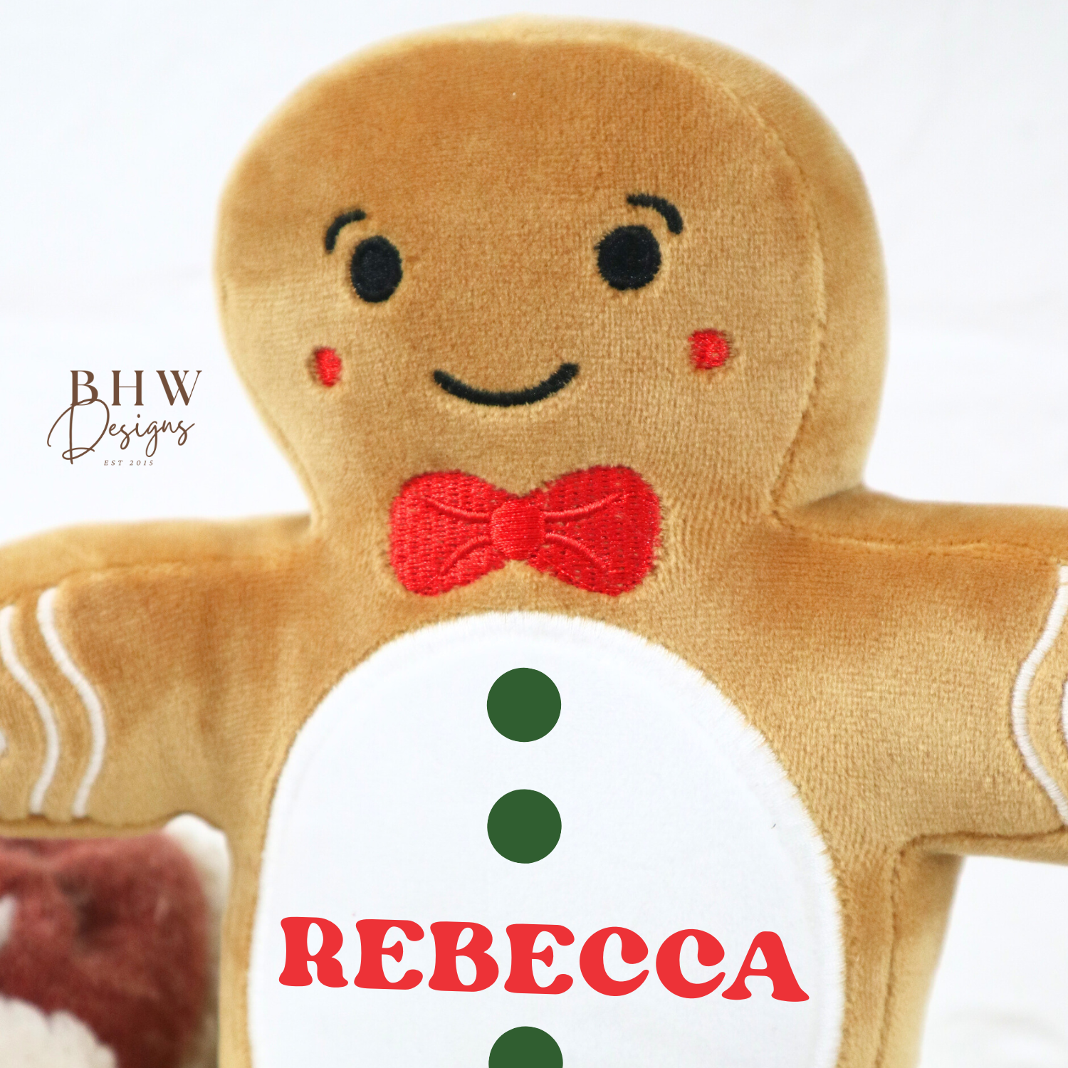Plush gingerbread man toy with a name tag on a white background