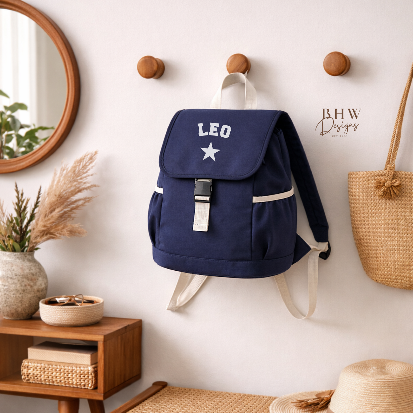 Navy blue backpack with 'LEO' and a star on a wall hook, next to a wooden bench with a hat and shoes.
