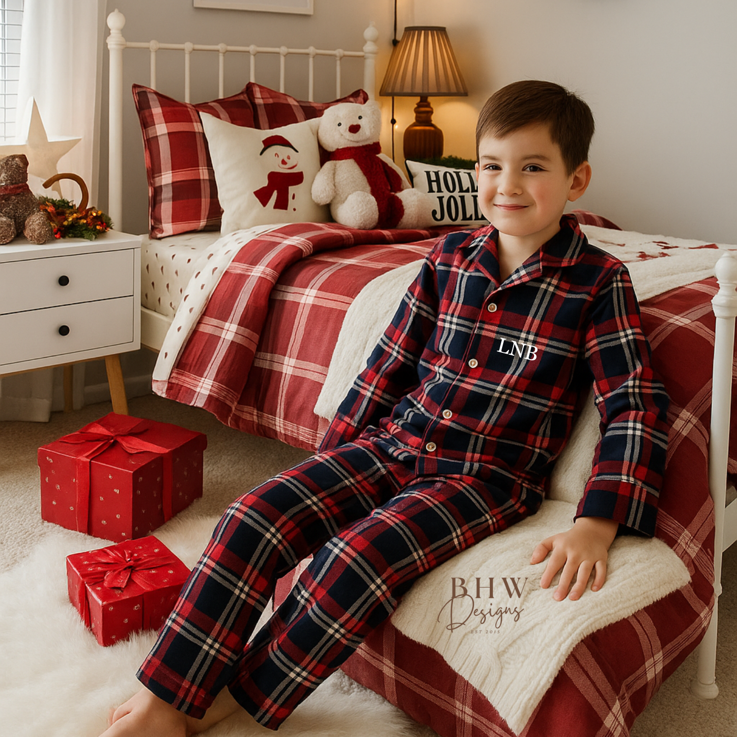 Boy wearing a red and blue plaid pyjama set with 'LNB' initials. 