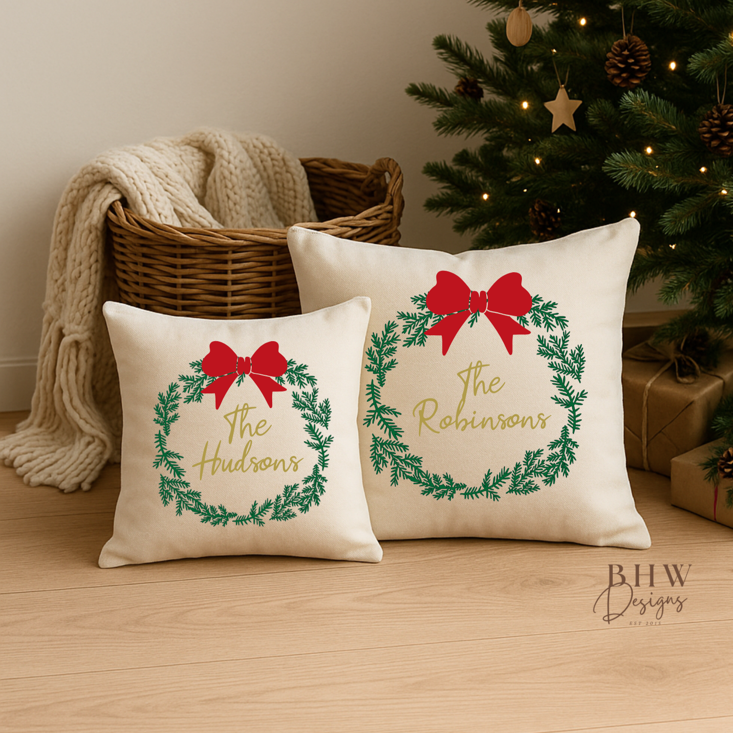 Two decorative personalised wreath and bow design cushion covers in front of a decorated tree.