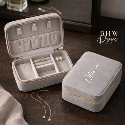 Grey velvet jewellery box with 'Olivia' on the top on a wooden surface, featuring jewellery inside.