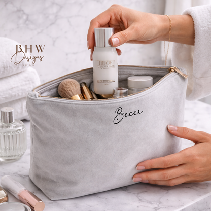 Person holding a makeup bag with skincare products on a marble surface, featuring BHW Designs branding.