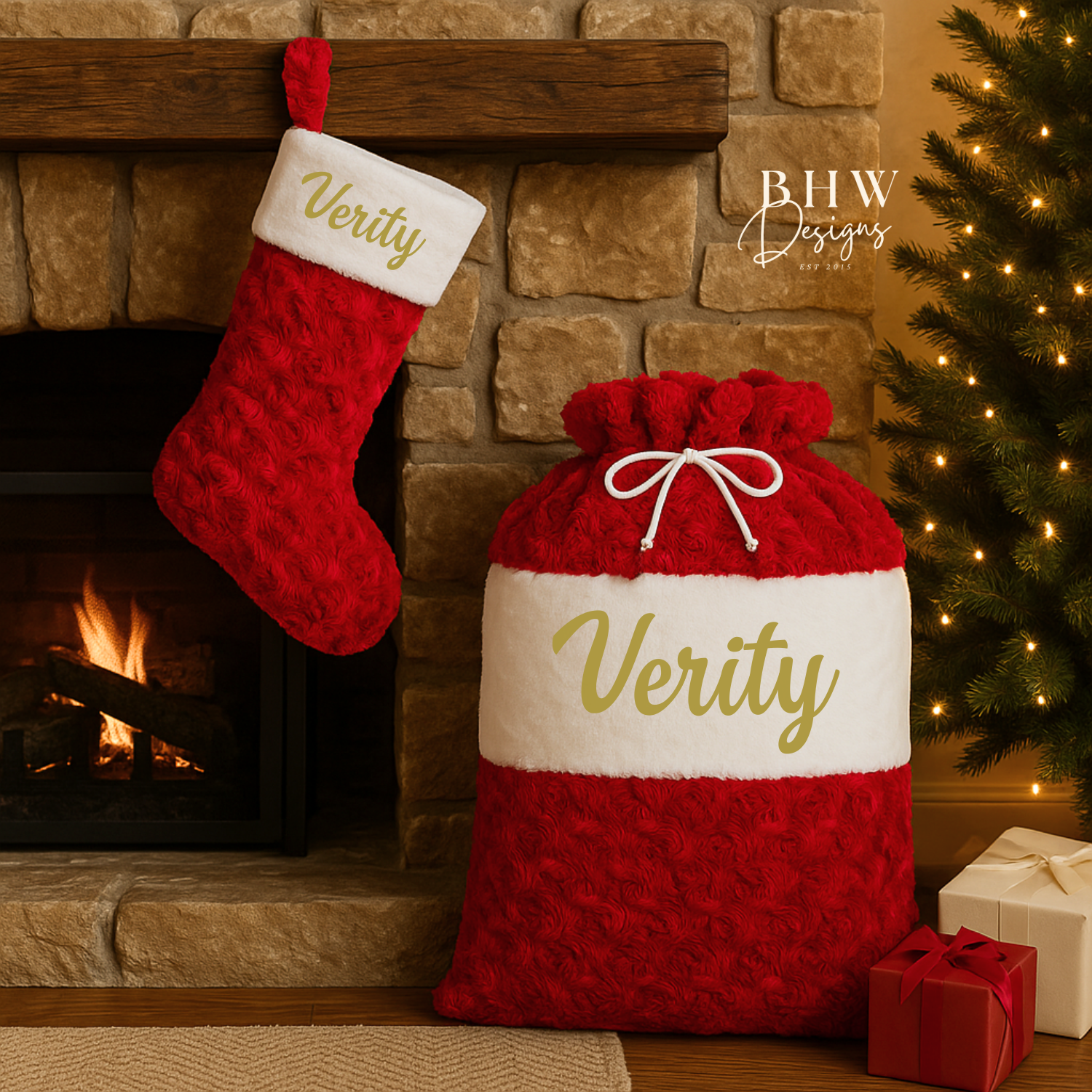 Red and white Christmas sack with 'Verity' in gold next to a matching red stocking, in front of a fireplace and Christmas tree.