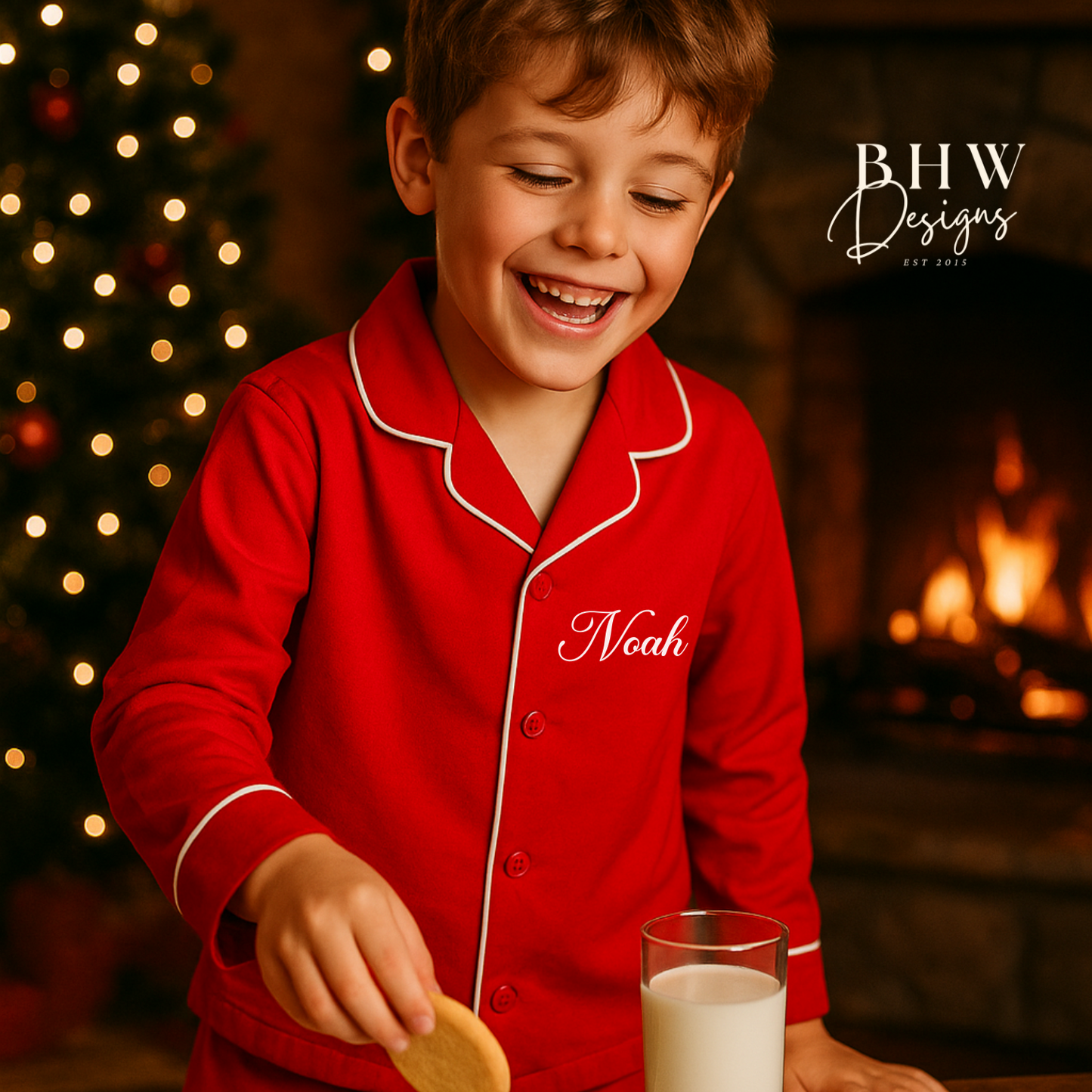 Child in red classic pyjamas with 'Noah' on a Christmas-themed background with a tree and fireplace.