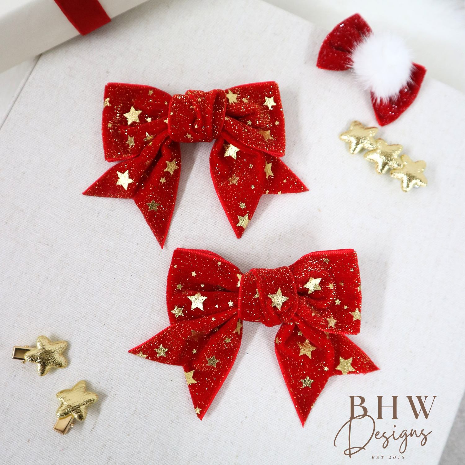 Red glittery bows with gold stars on a white surface