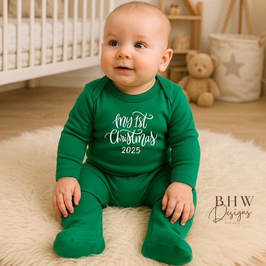 Baby in a green 'My 1st Christmas' onesie sitting on a rug in a nursery.