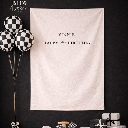 White banner with 'Vinnie Happy 2nd Birthday' text, black and white balloons on a dark background.