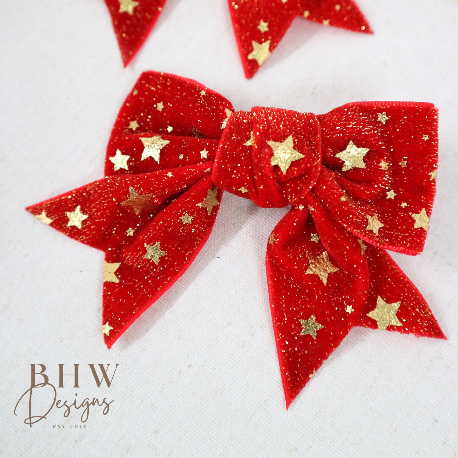 Red glittery bows with gold stars on a white background