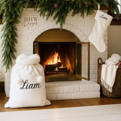 Cozy fireplace with Christmas decorations, including white personalised stockings and a sack with 'Liam' in black