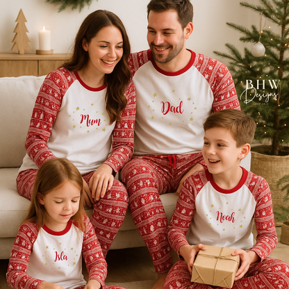 Family of four wearing matching personalised red and white fair isle print pyjamas in a festive setting with a Christmas tree.