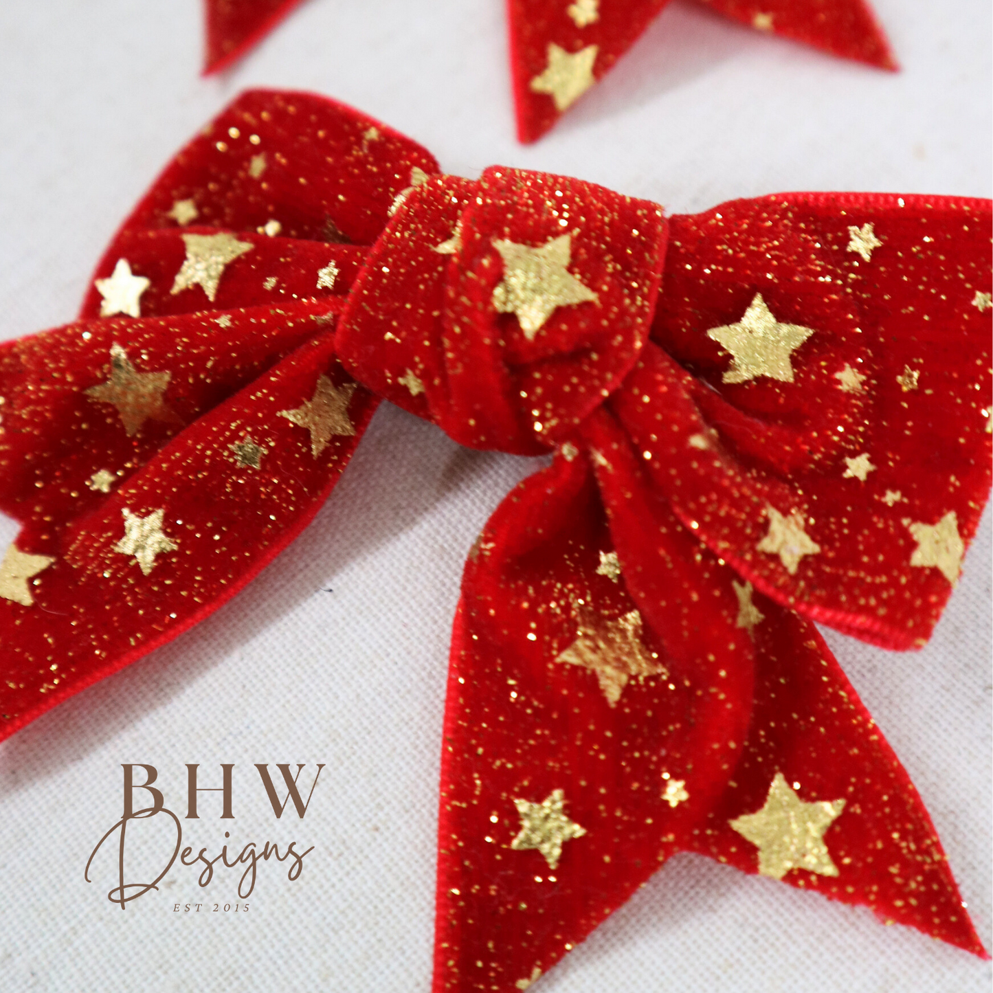 Red glittery bows with gold stars on a white background,