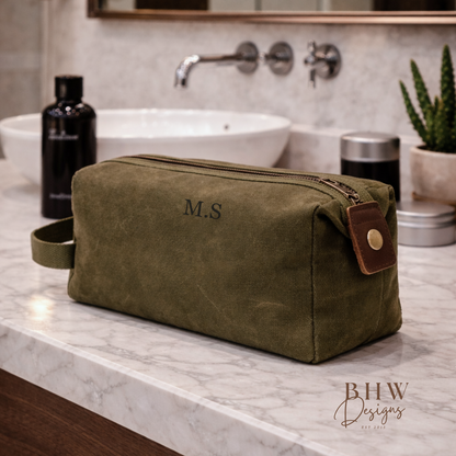 Green toiletry bag with initials on a bathroom counter, featuring 'BHW Designs'.