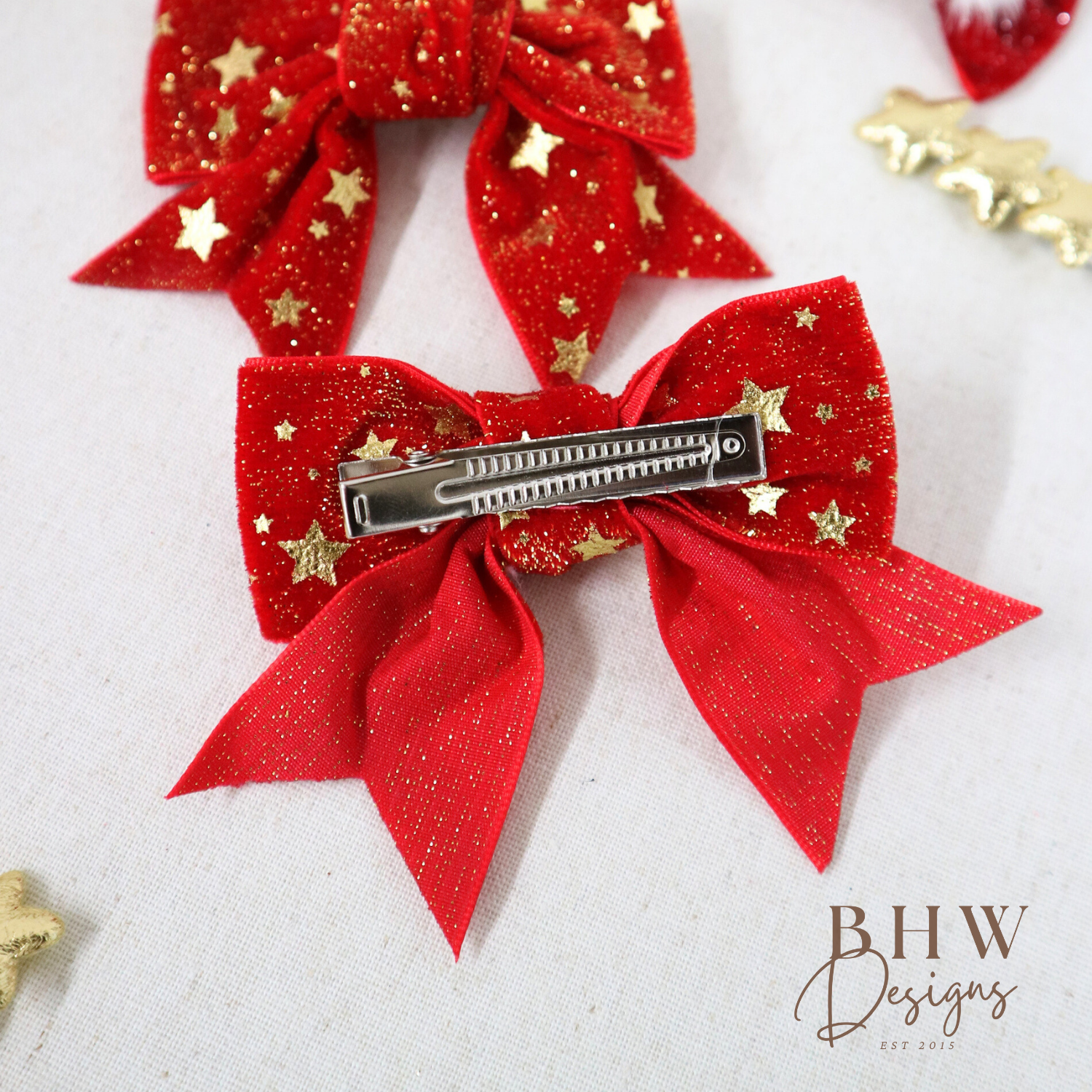 Red glittery hair bow with gold stars and a barrette on