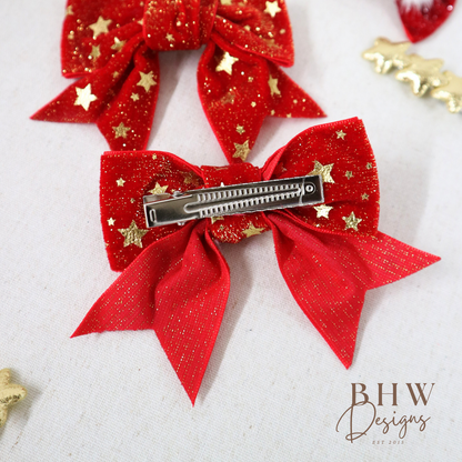 Red glittery hair bow with gold stars and a barrette on
