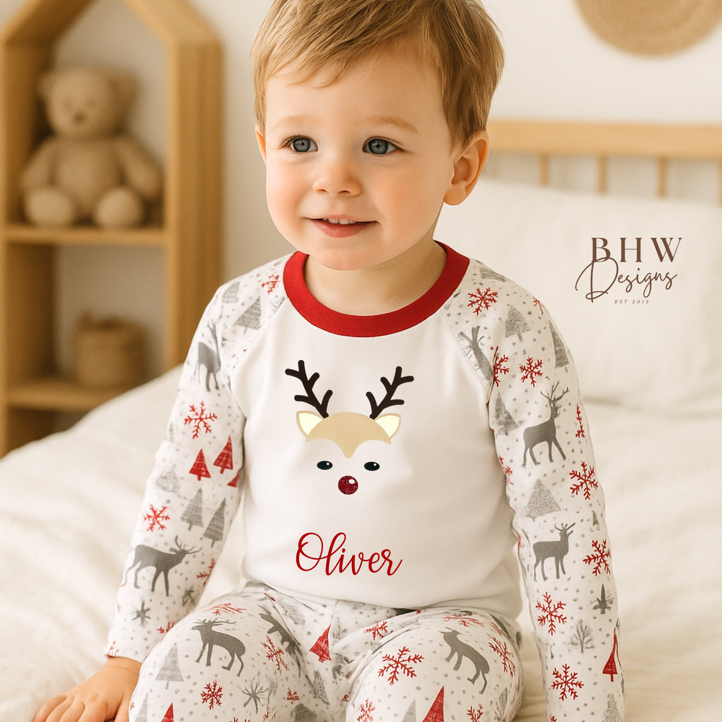 Child wearing personalised pyjamas set with a reindeer design and 'Oliver' 