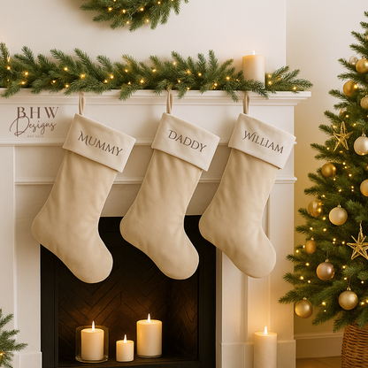 Decorative personalised beige stockings hanging above a fireplace 