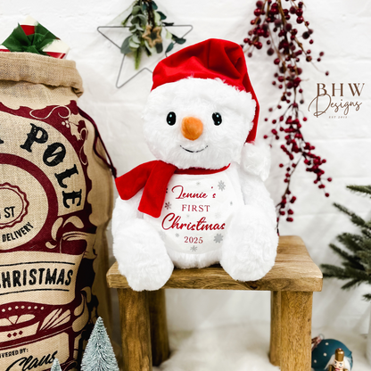 White snowman plush toy with red hat and scarf personalised on the front with a name and First Christmas 2025 on the front 