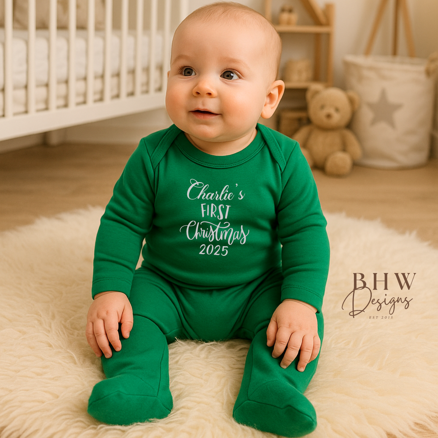 Baby wearing a green 'Charlie's First Christmas 2025' onesie in a nursery setting.
