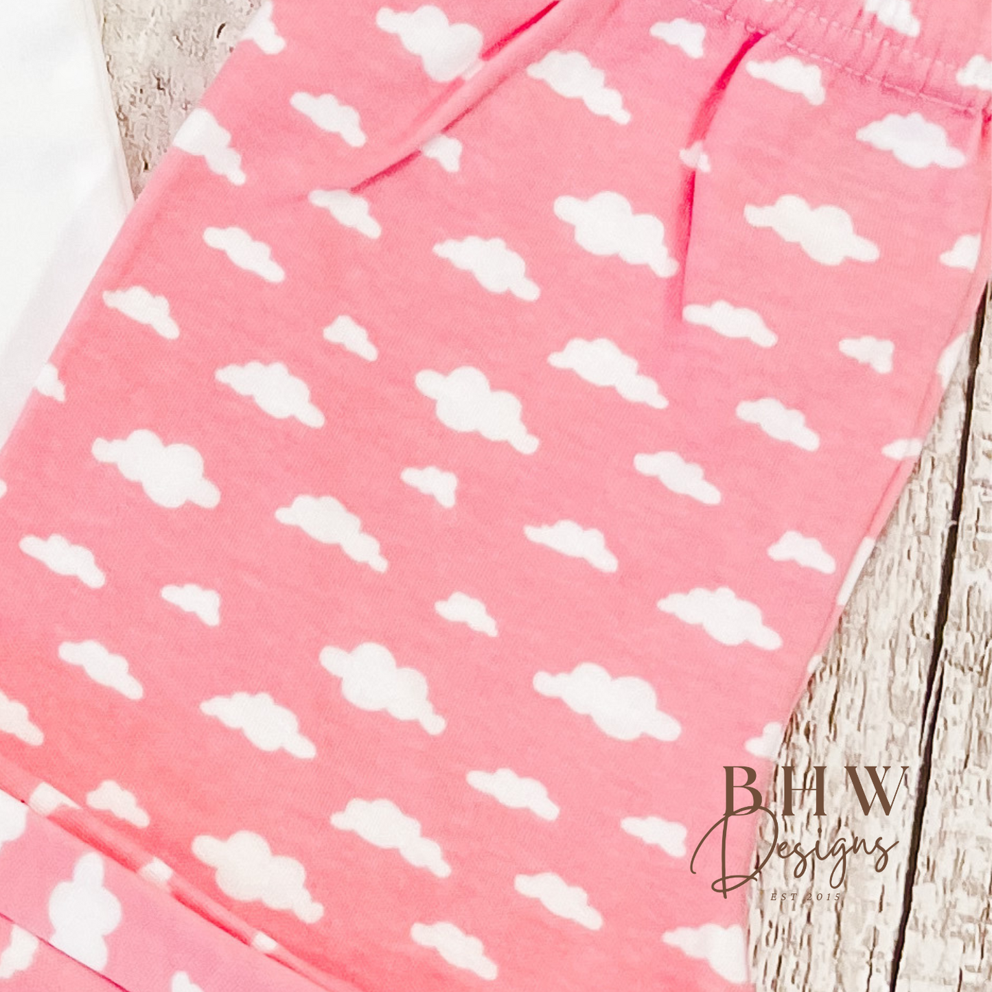 Pink pyjamas with white cloud pattern.