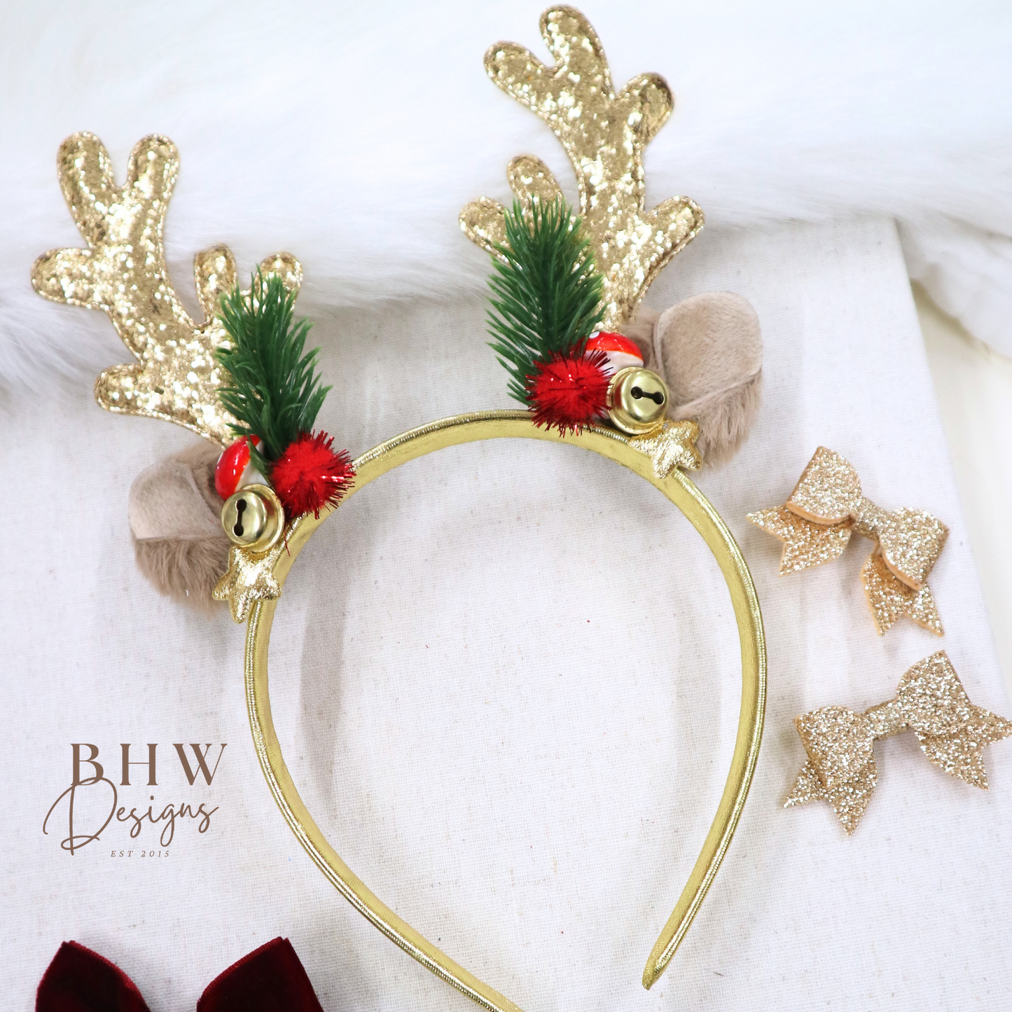 Gold reindeer antler headband with green leaves, red berries, and gold stars on a white background.