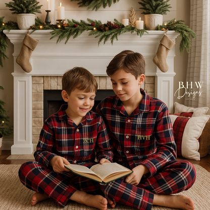 Two boys wearing a red and blue plaid pyjama set with initials on the front