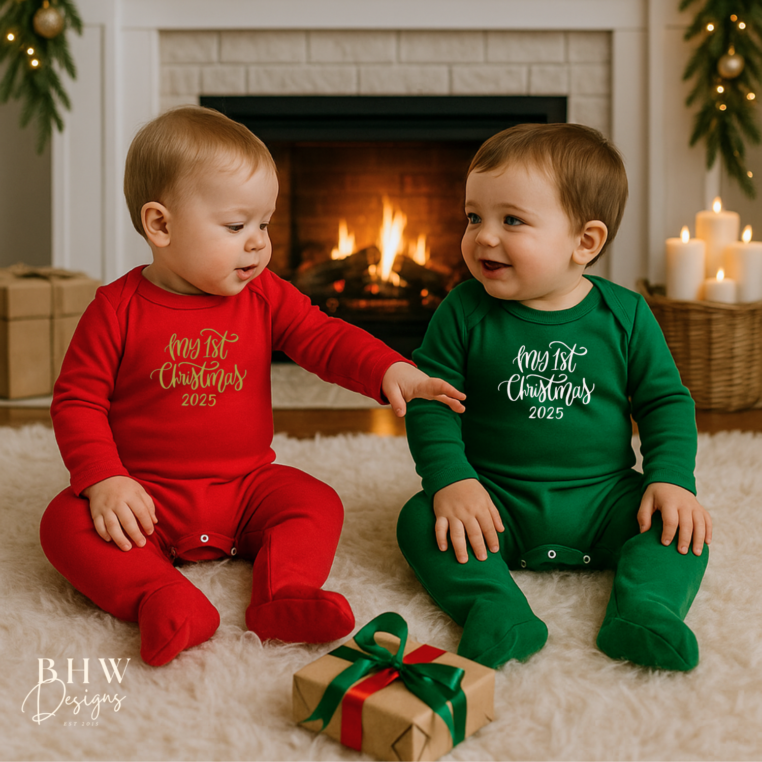Two children in red and green Christmas-themed outfits with My first christmas on the front, sitting on a rug with a fireplace and gift in the background.