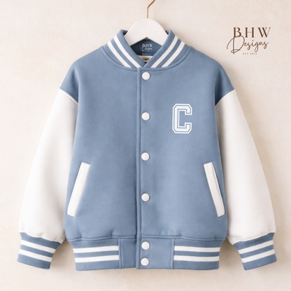 Blue and white varsity jacket with a letter 'C' on a hanger against a beige background