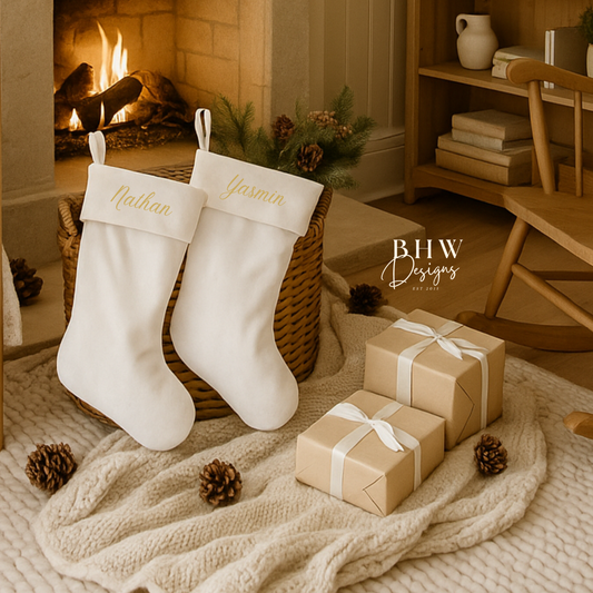 White personalised Christmas stockings and gift boxes in front of a fireplace with 'BHW Designs' branding.