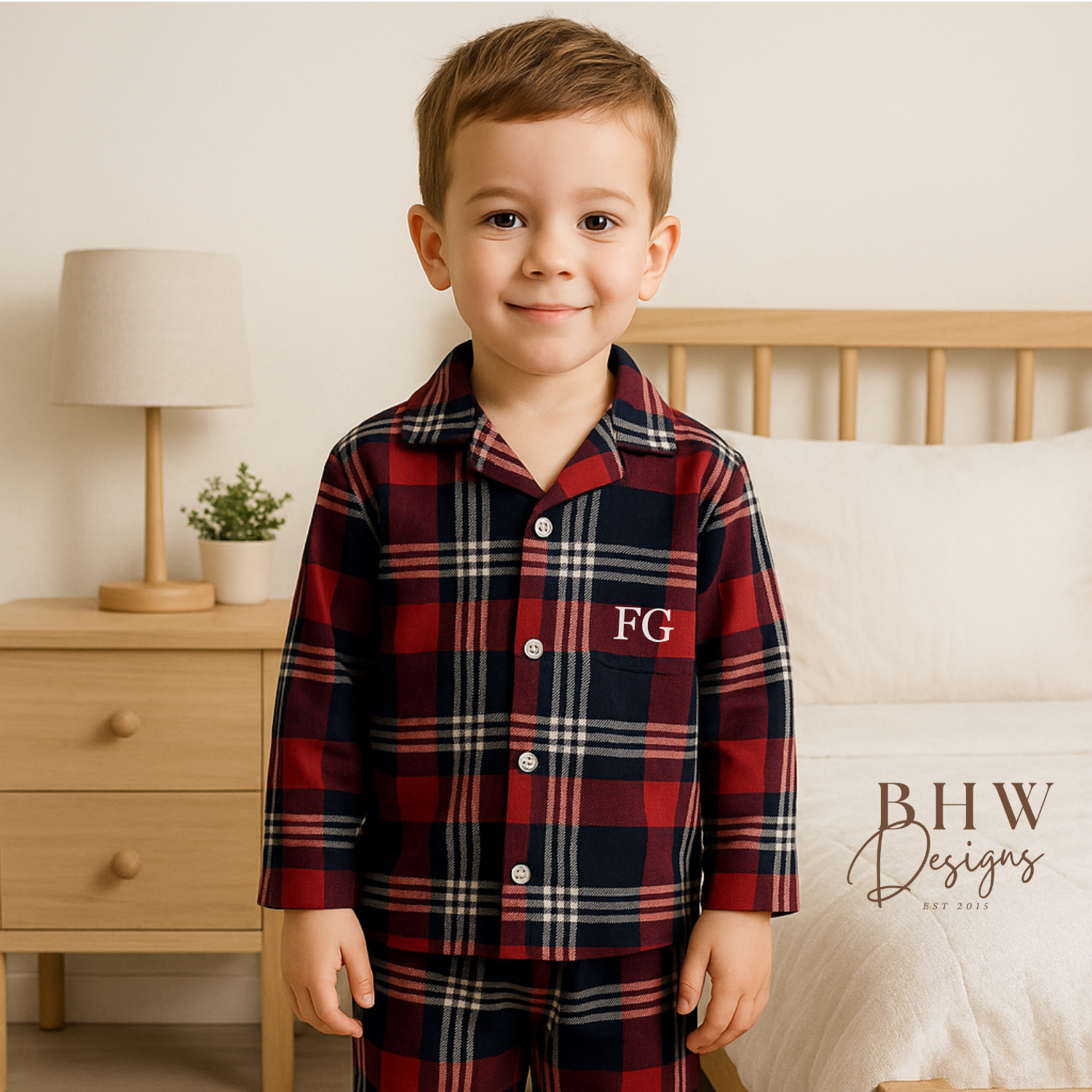 Child wearing a red and blue plaid pyjama set with 'FG' initials. 