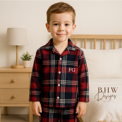 Child wearing a red and blue plaid pyjama set with 'FG' initials. 