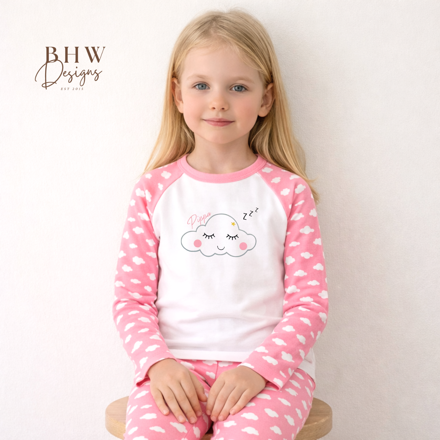 Young girl wearing pink and white cloud print pyjamas 