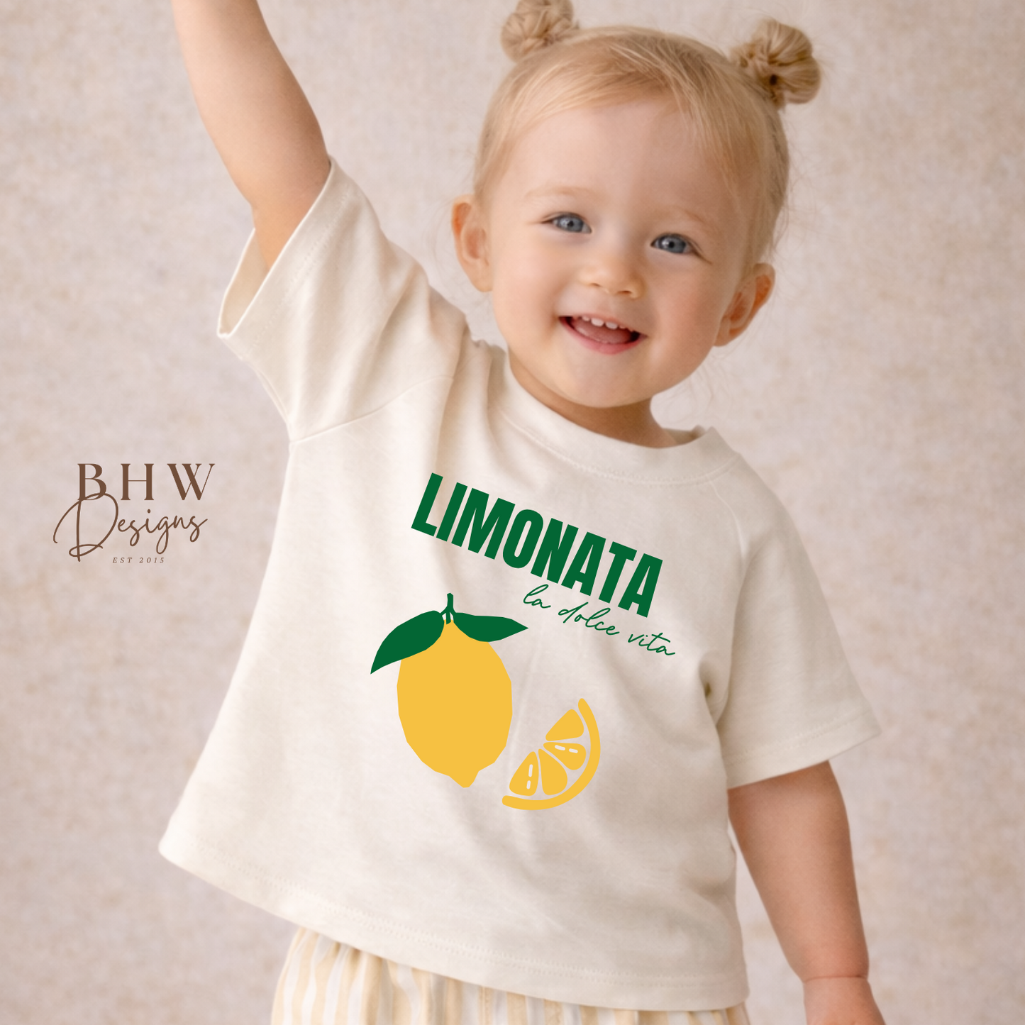 Child wearing a 'Limonata' t-shirt with lemon graphics on a beige background