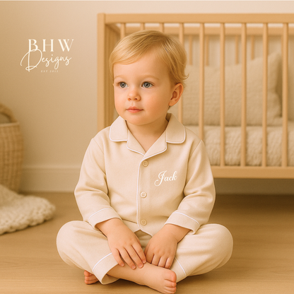 Child wearing a beige cotton pyjamas with Jack printed on it.