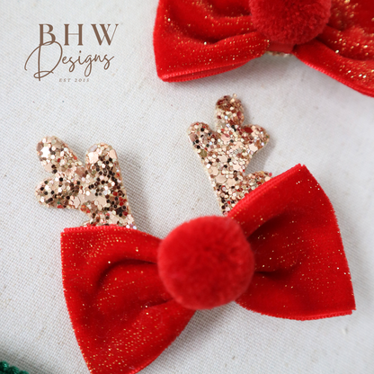 Red glittery hair bows with pom-poms on 