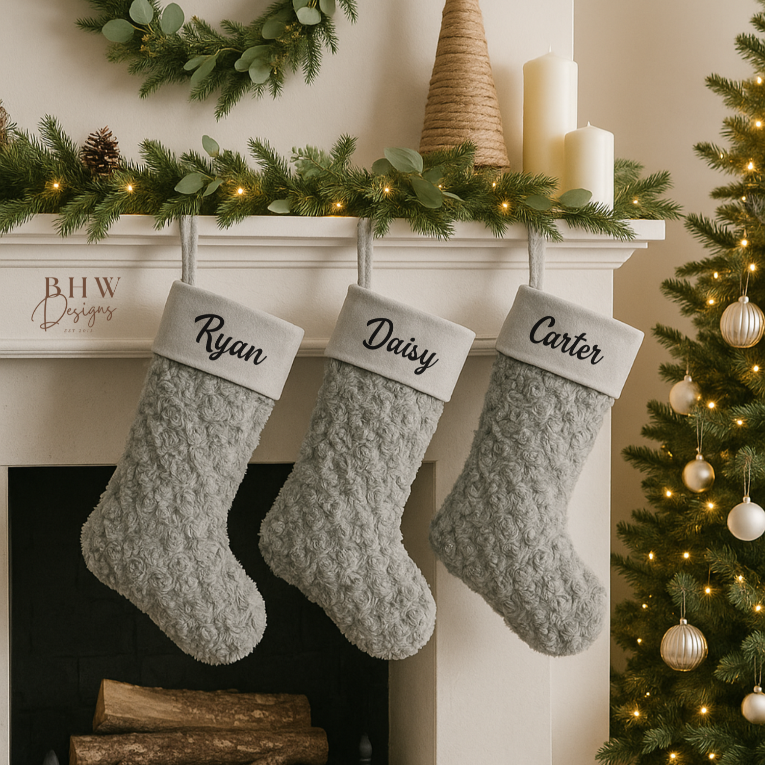 3 Grey stockings with personalised names hanging on a fireplace mantel decorated for Christmas.