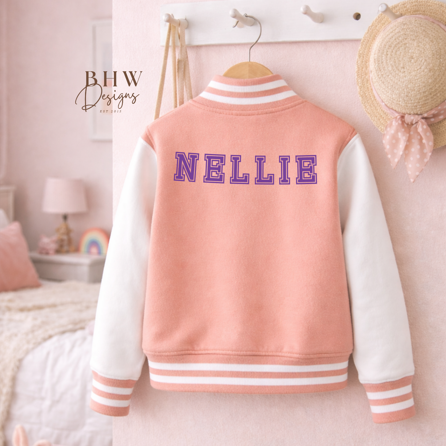 Peach Pink varsity jacket with 'NELLIE' on the back in purple in a bedroom setting