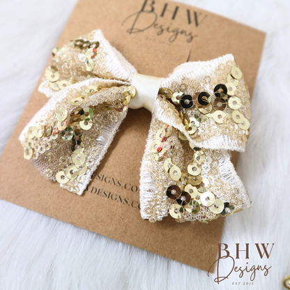 Gold sequin bow on a brown card with 'BHW Designs' branding