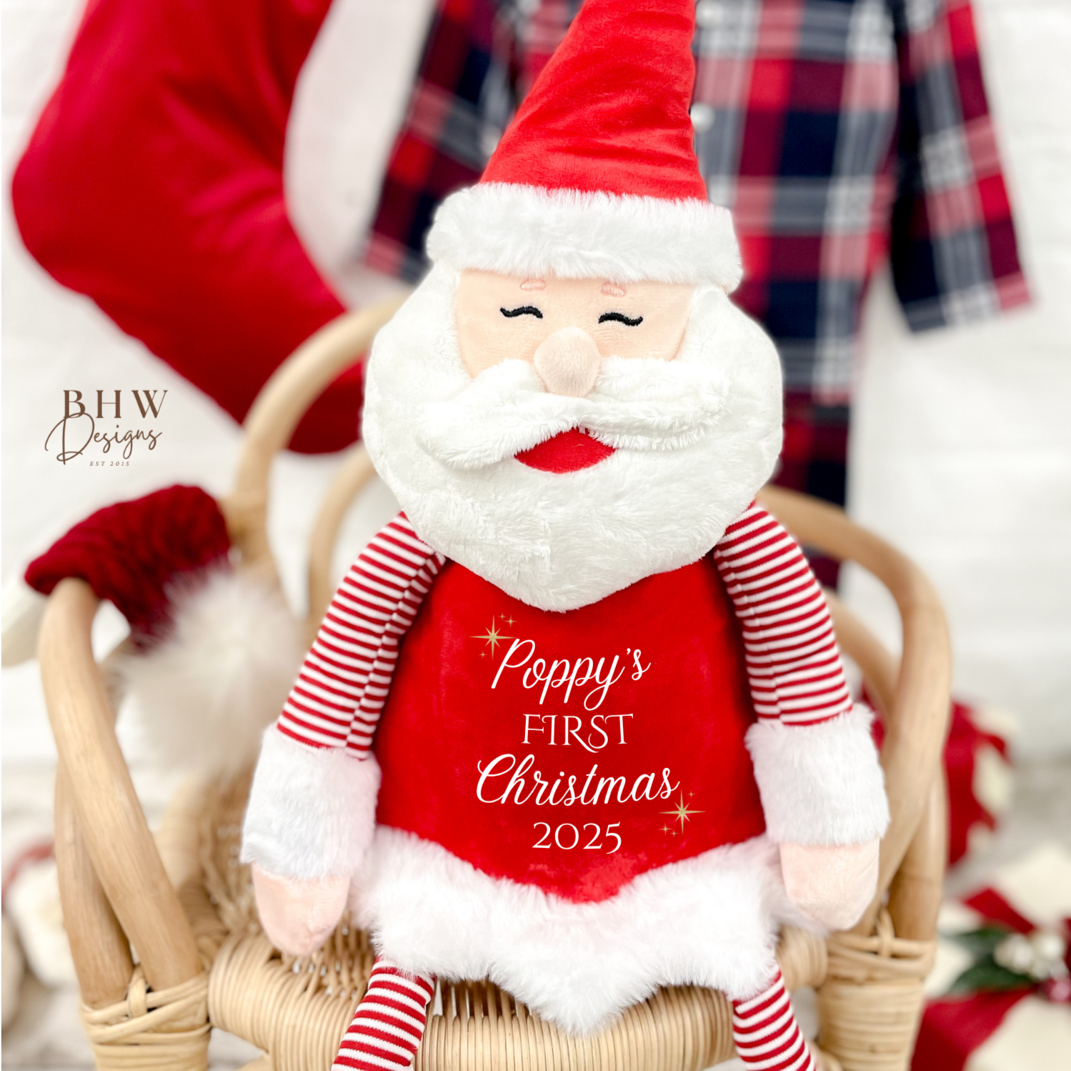 Plush Santa Claus toy with 'Poppy's First Christmas 2025' text, sitting in a basket.